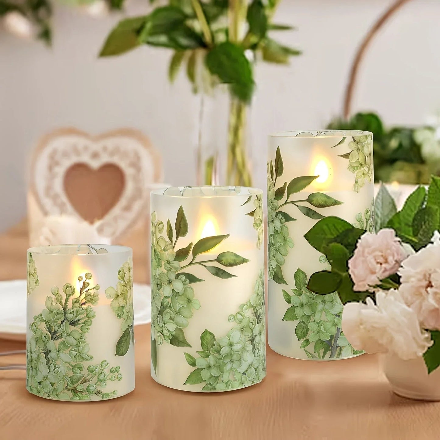 A set of 3 flameless candles, flickering LED pillar candles, with a 10-button remote control. They feature a green floral theme, are suitable for spring and summer, and can be used on the dining tables at wedding venues